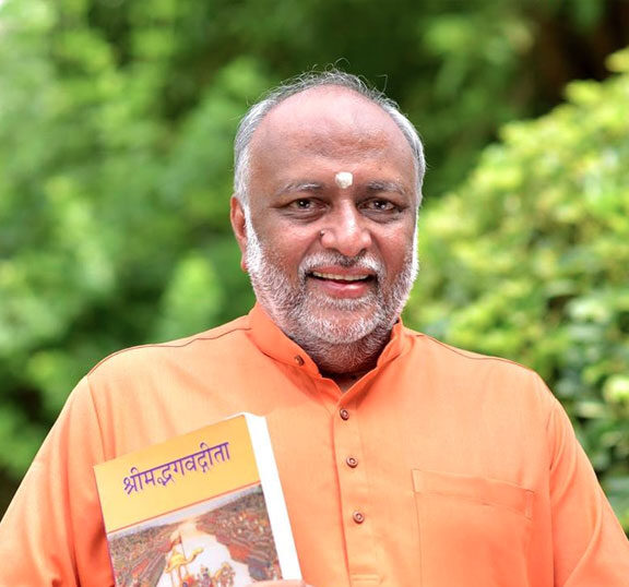 Swami Sukhabodhananda holdiing bhagvad geeta